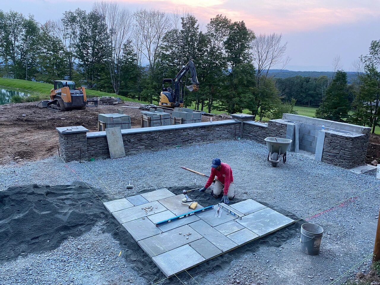 Hardscape construction with paver patio and stacked-stone wall in Princeton Junction, NJ. New Dawn Landscaping.